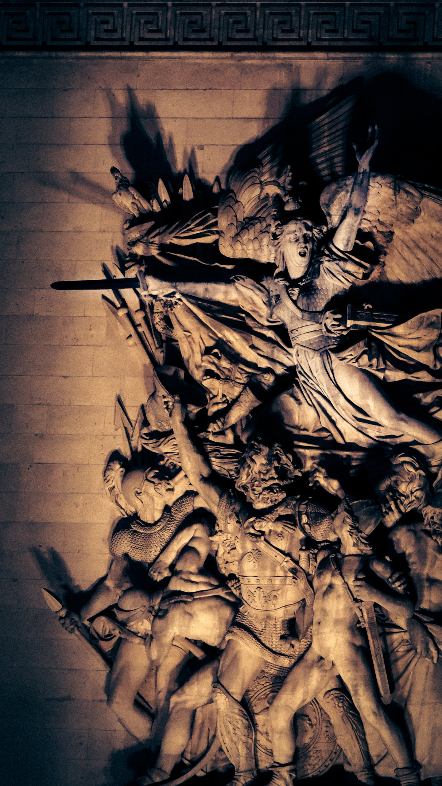 A sculpted architectural relief lit in warm and cool tones.