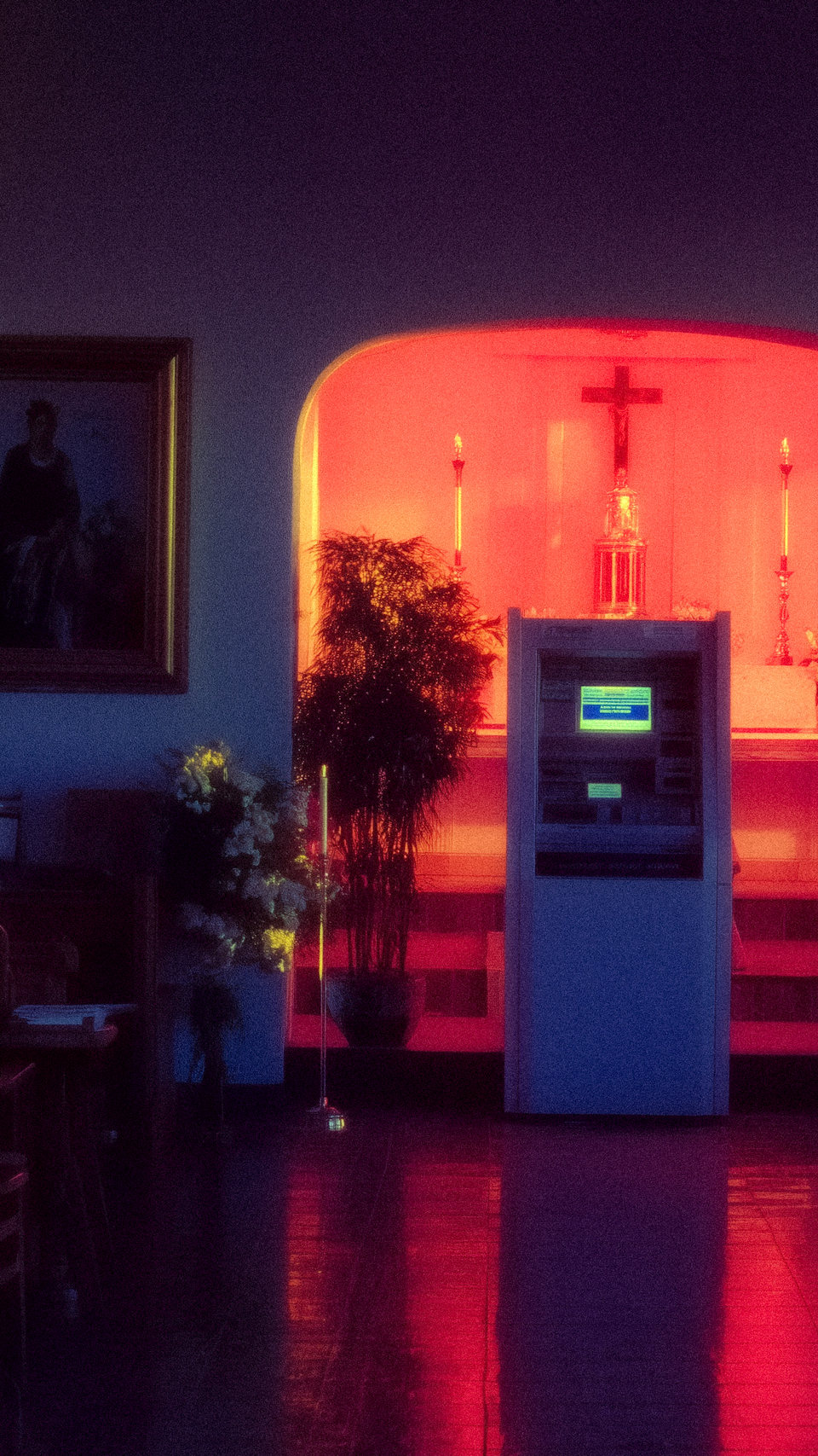 A machine standing in an empty interior lit by blue and red arches.